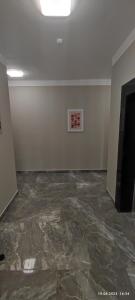 アスタナにあるУютное место локация Хан-Шатыр,G8の大理石フロアの客室で、壁に絵画が飾られています。