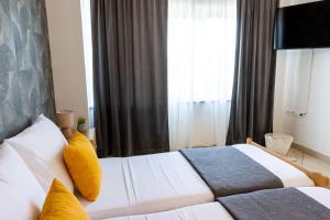 a hotel room with two beds and a television at DELUXE ROOMS BURE in Murter +3 photos
