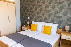 a bedroom with a large bed with yellow pillows at DELUXE ROOMS BURE in Murter