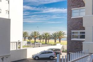 a car parked in a parking lot next to a building at Little Gem On The Promenade in Cape Town