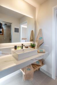 een badkamer met een witte wastafel en een spiegel bij Ida Village in Chersonissos