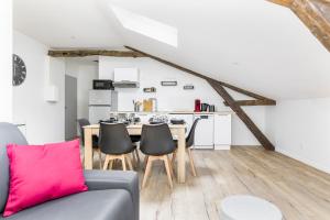 a living room with a couch and a table with chairs at Gambetta 403 CahorsCityStay in Cahors