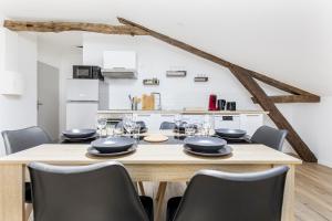 a dining room with a wooden table and chairs at Gambetta 403 CahorsCityStay in Cahors