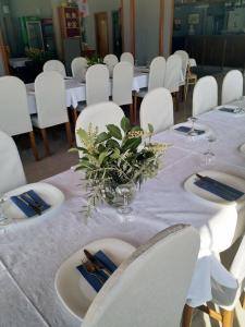 a dining room with white tables and white chairs at Pansion Palma in Međugorje