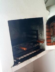 un horno de ladrillo con dos perritos calientes. en Casa da Avó Mirinha en Figueira e Barros