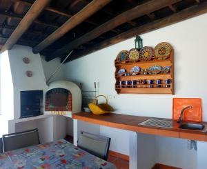 a kitchen with a counter and a table with a sink at Casa da Avó Mirinha in Figueira e Barros