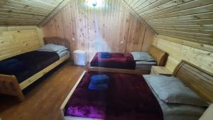 a room with two beds in a wooden cabin at Kesane in Jut'a