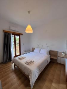 - une chambre avec un grand lit blanc et une lumière dans l'établissement Sifnos Valley, à Faros