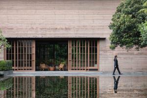 a person walking in front of a building at Numazu Club in Numazu