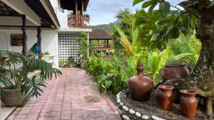 a garden with vases and a brick walkway at Private 2 bedrooms in Munduk