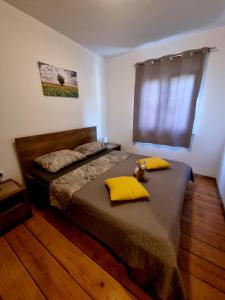 Un dormitorio con una cama con almohadas amarillas y una ventana en Apartments Ema, en Pula