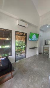 een woonkamer met een bank en een televisie aan de muur bij Cheeva at pai ชีวา แอท ปาย in Pai