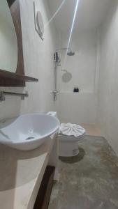 ein weißes Bad mit einem Waschbecken und einem WC in der Unterkunft Cheeva at pai ชีวา แอท ปาย in Pai