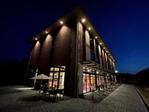 a building with tables and chairs outside at night at Ferienbahnhof Reichenbach in Dahn