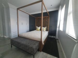 een slaapkamer met een hemelbed en een bank bij Royal Manor in Johannesburg