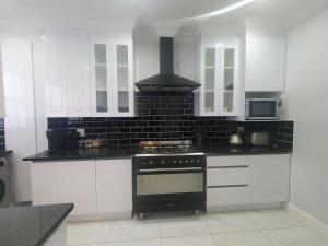 a kitchen with white cabinets and a stove top oven at Royal Manor in Johannesburg