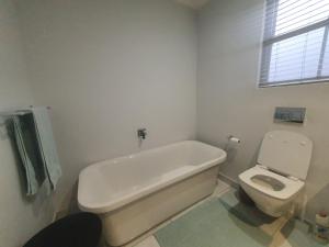 a bathroom with a bath tub and a toilet at Royal Manor in Johannesburg