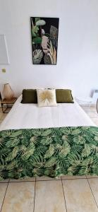 a bed with a green blanket on the floor at A mi-chemin in Vannes