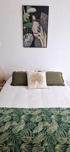 a bed with a green and white comforter on it at A mi-chemin in Vannes