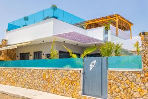 a house on the beach with a stone wall at City Compass Luxury Villa in Faliraki