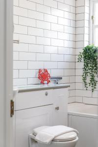 a white bathroom with a red ribbon sitting on a counter at Beachfront Getaway 2-Bedroom House with FREE Private Parking & Patio in Brighton & Hove