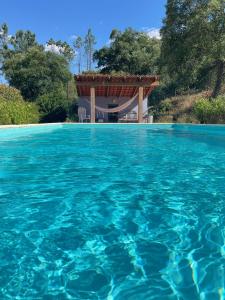a swimming pool with a gazebo in the water at Quinta do Eco in Vila de Rei