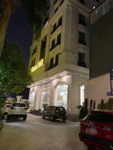 a building with cars parked in a parking lot at Grand Hill Hotel & Apartment in Hai Phong