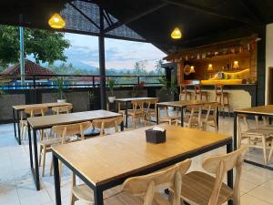 a restaurant with wooden tables and chairs and a counter at Pondok Tetebatu Cottages and Cafe in Tetebatu