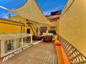 einen Balkon eines Hauses mit einer Holzterrasse in der Unterkunft House -Rooftop&Jacuzzi -StayInSeville in Sevilla