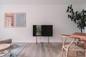 a living room with a flat screen tv on a wall at Apartment Søglas in Gmund am Tegernsee