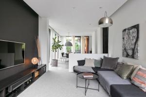 un soggiorno con divano e TV a schermo piatto di Swedish Elegance & Luxury Home a Stoccolma
