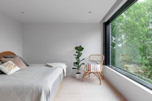 a bedroom with a bed and a large window at Swedish Elegance & Luxury Home in Stockholm