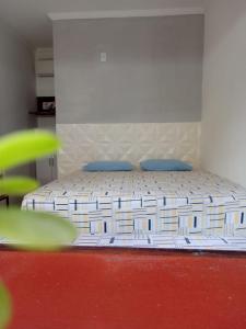 a bed with blue pillows in a room at Pousada Recanto da Vila in Piranhas