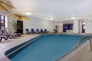 a pool in a hotel room with chairs and tables at Days Inn by Wyndham Niagara Falls Near The Falls in Niagara Falls