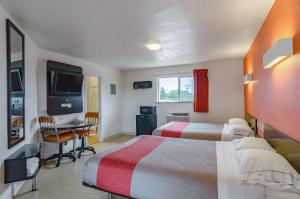 a hotel room with two beds and a flat screen tv at Motel 6 Riverton WY in Riverton