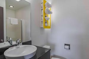 Un baño con lavabo, inodoro y espejo. en Motel 6 Riverton WY, en Riverton 37 fotos más