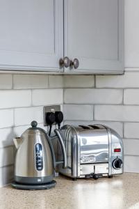 a toaster sitting on a kitchen counter next to a toaster at Beachfront Getaway 2-Bedroom House with FREE Private Parking & Patio in Brighton & Hove