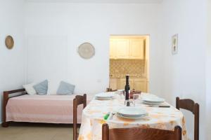 サン・パスクアーレにある[8 min dal mare] Casa di Danielaのテーブルとベッドが備わる客室です。