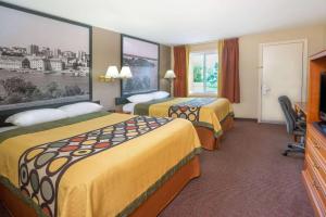 a hotel room with two beds and a television at Super 8 by Wyndham Kingston in Kingston