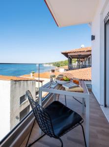 a balcony with a table and a chair at Aiora Suites by Booking Kottas in Psakoudia