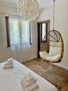 a room with a swing chair and a bed at Boutique Country House Serendipity in Cantiano