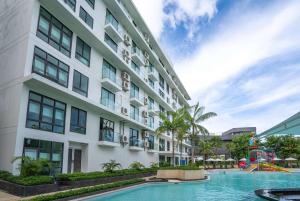an apartment building with a pool and a playground at Wyndham La Vita Rawai Phuket in Rawai Beach