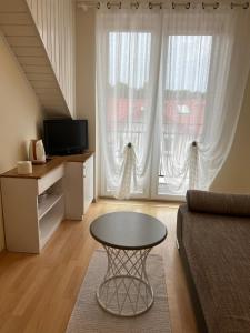 - un salon avec une table devant une grande fenêtre dans l'établissement Magdalena, à Karwia