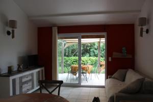 a living room with a couch and a sliding glass door at MINI VILLA PALOMBAGGIA - Piscine chauffée in Porto-Vecchio +16 photos