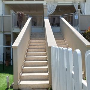 una escalera que conduce a una casa con una valla blanca en casa mare Itaca, en Policoro