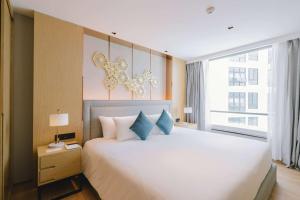 a bedroom with a large bed and a large window at Wyndham La Vita Rawai Phuket in Rawai Beach