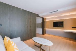 a living room with a couch and a table and a tv at Wyndham La Vita Rawai Phuket in Rawai Beach