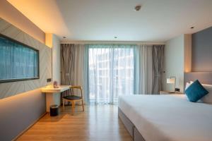 a hotel room with a large bed and a desk at Wyndham La Vita Rawai Phuket in Rawai Beach