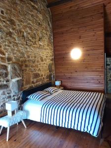 ein Schlafzimmer mit einem Bett in einer Ziegelwand in der Unterkunft SCIOTOT-BORD DE MER - LA GRANGE in Les Pieux