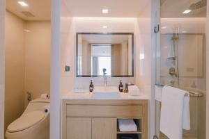 a bathroom with a sink and a shower and a toilet at Wyndham La Vita Rawai Phuket in Rawai Beach